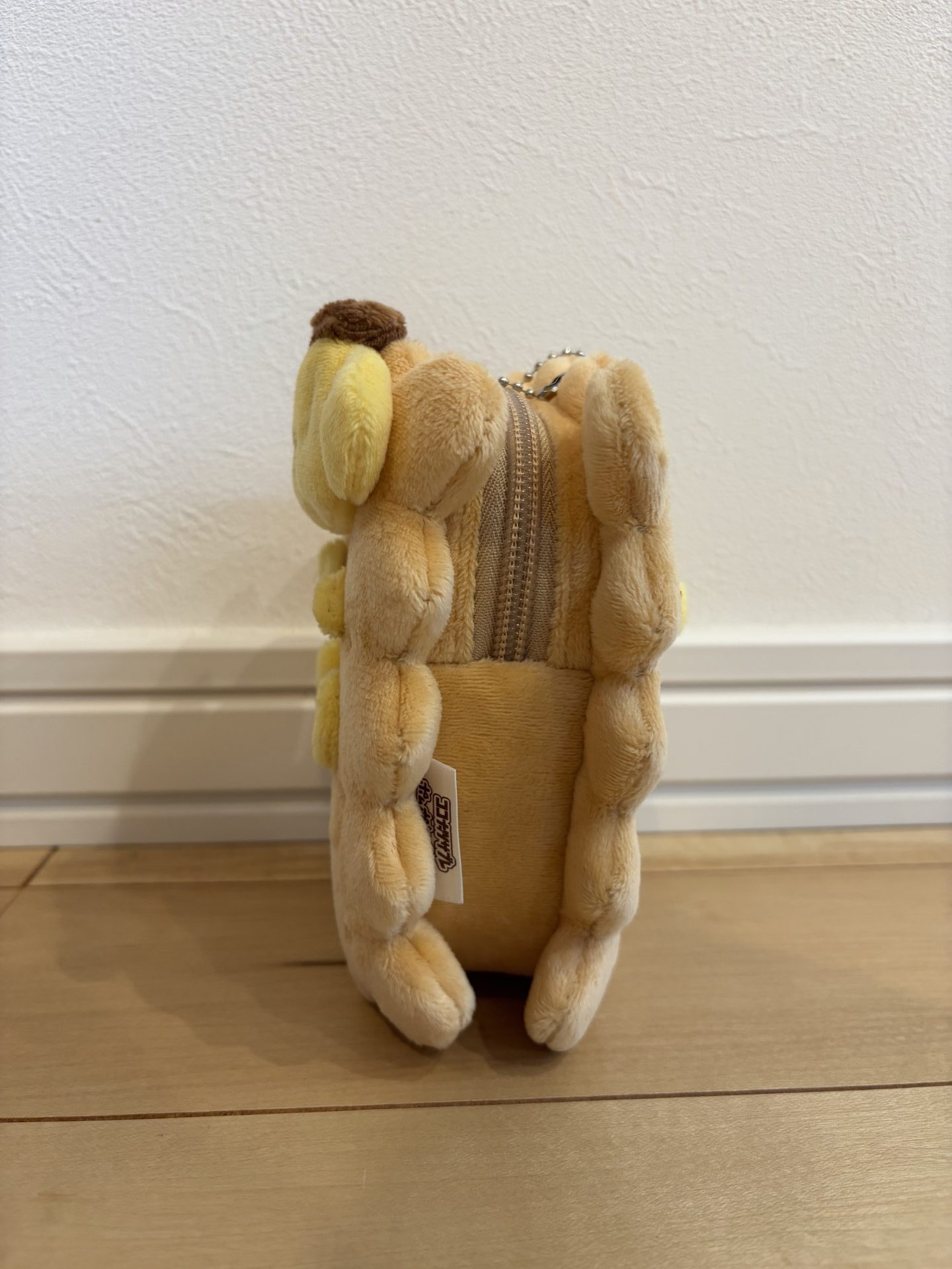 ポムポムプリンがココナッツサブレに挟まったデザインのぬいぐるみポーチ。横。